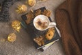 Autumn lifestyle home decor with books and coffee or hot chocolate cup, woolen sweaters and lights