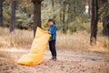 Autumn lifestyle of man inflates an inflatable sofa in forest. Relaxing and enjoying life on air bed banner format Royalty Free Stock Photo