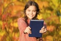 Autumn literature concept. Small child enjoy reading autumn foliage background. Little child enjoy learning in autumn