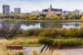 Autumn. Lonely bench by the river with a view of Saskatoon downtown