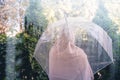 Autumn. Lonely muslim woman in a headscarf under a transparent umbrella. View through a window with raindrops. Rainy day.