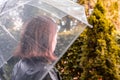 Autumn. Lonely sad woman under a transparent umbrella with rain drops walking in a park, garden. Rainy day landscape. Royalty Free Stock Photo