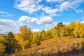 Autumn Majestic Scenery: Hill Covered by Fall Forest and Blue Sky with White Clouds Royalty Free Stock Photo