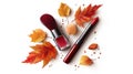 Autumn Makeup Collection Red Lipstick and Brush with Fall Leaves Royalty Free Stock Photo