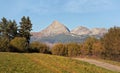 Autumn meadows near country road, mount Krivak peak Slovak symbol as seen from Vazec village  in distance Royalty Free Stock Photo
