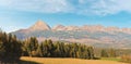 Autumn meadows near country road, panorama of Tatry mountains with Krivak peak Slovak symbol as seen from Vazec village in Royalty Free Stock Photo