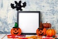 Autumn minimal composition. Helloween holiday concept. Photo frame, pumpkins in caps and a bat against a light wall. Front view, Royalty Free Stock Photo