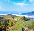 Autumn misty morning plateau with stack of hay and country dirty road (Carpathian Mountains, Ukraine Royalty Free Stock Photo