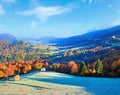 Autumn misty morning valley with stack of hay and village view (Mighgirya village outskirts, Carpathian Mountains, Ukraine Royalty Free Stock Photo