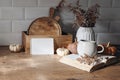 Autumn mockup scene. Blank card, open book, cup of coffee, wooden chop boards and dry fern leaves in sunlight. Fall