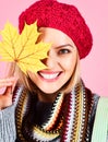 Autumn model. Closeup portrait of smiling woman with maple leaf. Autumn mood. Beautiful girl in knitted beret, scarf and