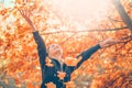 Autumn model girl spinning and laughing in autumnal park, forest, throws colorful leaves. Beautiful Young Woman Having Fun Royalty Free Stock Photo