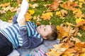 Autumn mood. The boy is thoughtfully drawing something in his notebook.Autumn portrait of a child in yellow foliage. Sight. Cute Royalty Free Stock Photo