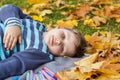 Autumn mood. The boy is thoughtfully drawing something in his notebook.Autumn portrait of a child in yellow foliage. Sight. A Royalty Free Stock Photo