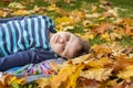 Autumn mood. The boy is thoughtfully drawing something in his notebook.Autumn portrait of a child in yellow foliage. Sight. A Royalty Free Stock Photo