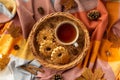Autumn mood concept. Top view photo of wicker basket with cup of tea homemade cookies cinnamon sticks anise yellow maple leaves Royalty Free Stock Photo