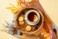 Autumn mood concept. Top view photo of wicker tray with cup of tea on saucer cookies anise yellow maple leaves pine cones and Royalty Free Stock Photo