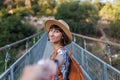 autumn mood. A female tourist walks along the bridge over the river. A young woman walks along a suspension bridge across a river Royalty Free Stock Photo