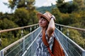 autumn mood. A female tourist walks along the bridge over the river. A young woman walks along a suspension bridge across a river Royalty Free Stock Photo