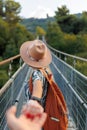 autumn mood. A female tourist walks along the bridge over the river. A young woman walks along a suspension bridge across a river Royalty Free Stock Photo