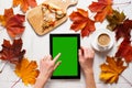 Autumn morning of contemporary young woman. Portable pc tablet, coffee and pizza on white timber table. Top view.