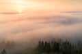 Autumn morning. Fog over valley in mountains illuminated by rising sun.