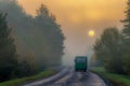 autumn morning landscape. Wet road after rain passes through the forest. The sun and trees are hidden in the fog. blur focus Royalty Free Stock Photo