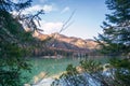 Autumn mountain landscape at Lake Braies. Hotel and old chapel on opposite bank of lake. View through conifer vegetation