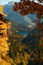 Autumn mountain landscape with yellow, orange and red foliage trees and green pines. Small Ritsla Lake View