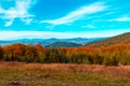 Autumn mountain landscape, yellow-red trees and blue mountains and sky in the background Royalty Free Stock Photo