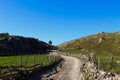 Autumn on the mountain. The road is surrounded by stone with wooden pillars connected by barbed wire. Mountain road that leads to