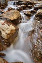 Red autumn leaf lying on wet stone  near a waterfall Royalty Free Stock Photo