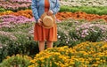 Autumn natural floral background. Girl with hat on background of colorful flowers in park. Botanical Garden. Growing Royalty Free Stock Photo