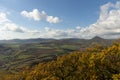 Autumn nature view from mountain to the horizon with hills and mountains and cloudy sky with trees in foreground Royalty Free Stock Photo