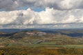 Autumn nature view from mountain to the horizon with hills and mountains and stone pit and cloudy sky Royalty Free Stock Photo