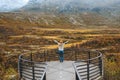 Autumn in Norway adventure travel outdoor woman raised hands on  Vegaskjelet viewpoint enjoying forest and mountains landscape Royalty Free Stock Photo