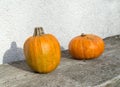 Autumn orange pumpkins on old wooden table against white wall. Organic food and healthy food