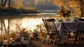 Autumn outdoor dinner table on a riverbank, with a simple wooden table and folding chairs