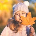 Autumn outdoor portrait of girl holds leaf