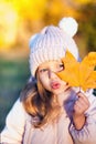 Autumn outdoor portrait of girl holds leaf