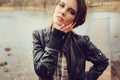 Autumn outdoor portrait of young beautiful woman with natural makeup in leather jacket and plaid shirt Royalty Free Stock Photo