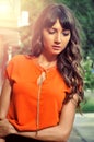 Autumn outfit color .Sophisticated brunette woman wearing elegant orange shirt with golden necklace Royalty Free Stock Photo