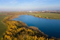 Autumn panorama. Aerial view on woods, lake and town. Sunny autumn day above woods and lake