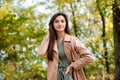 Autumn park. Beautiful woman in green dress posing in autumn park with yellow leaves Royalty Free Stock Photo