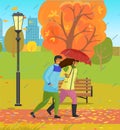 Autumn park, couple of happy girl and guy with umbrella walking in park under rain through wind Royalty Free Stock Photo