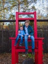 Autumn Park, entertainment. Two children sit on a large chair.