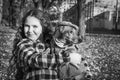 In the park, a girl holds a dachshund dog in her arms. Black and white photo Royalty Free Stock Photo