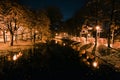 Autumn city park at night. Street lights and trees along the river. Royalty Free Stock Photo