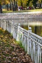 Autumn Park, trees reflected in the pond white rusty fence, withered leaves Royalty Free Stock Photo