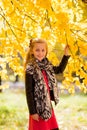 In autumn park walking little beautiful fashionable girl